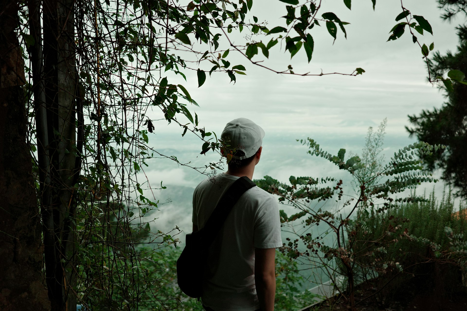 A man with a backpack looking out over the water